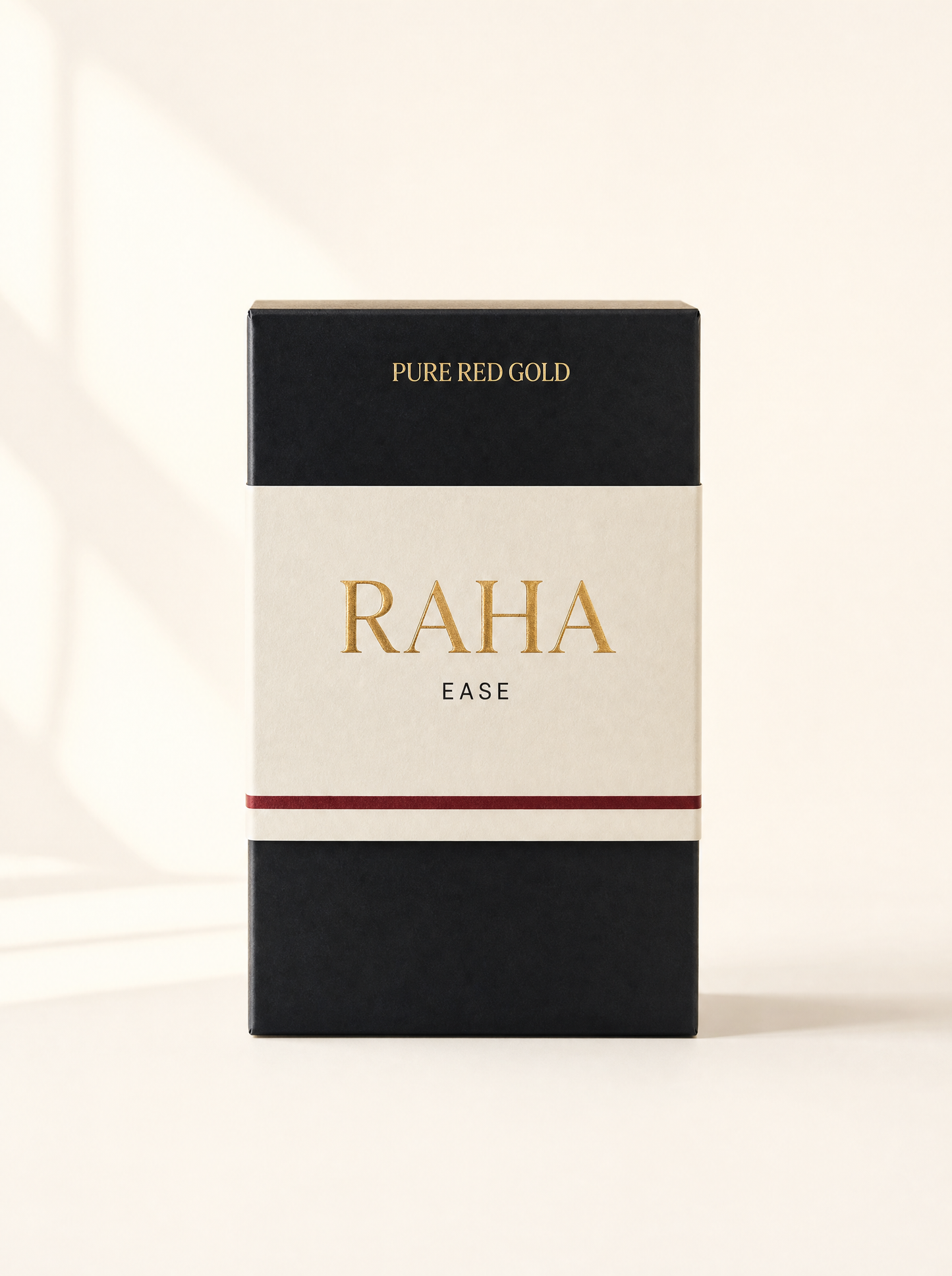 Raha herbal tea box — matte black with cream band, gold serif RAHA and EASE, on warm ivory