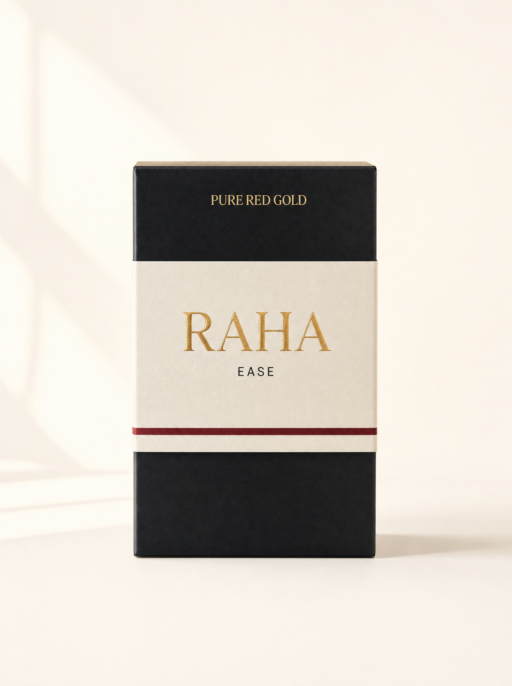 Raha herbal tea box — matte black with cream band, gold serif RAHA and EASE, on warm ivory