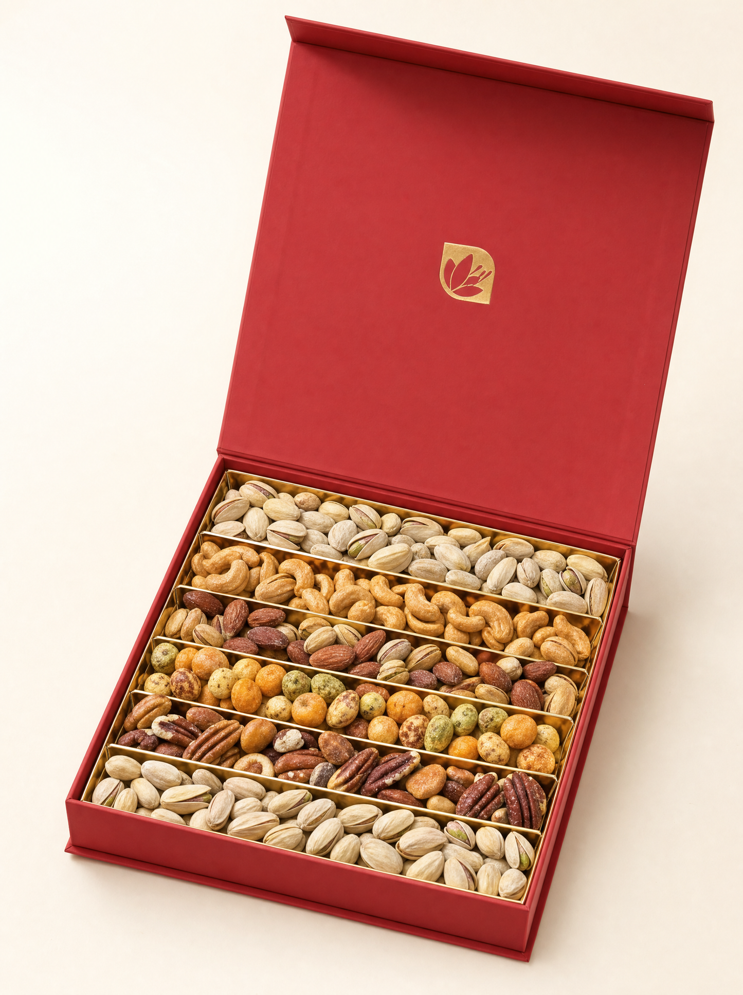 Open red gift box of premium roasted mixed nuts in a gold multi-row tray, on warm ivory
