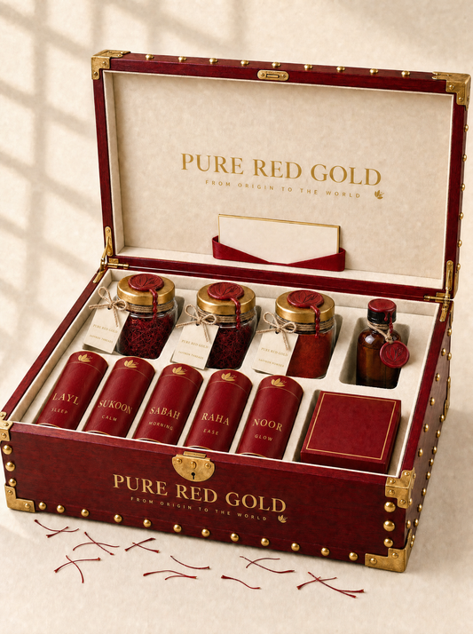 The MANDOOS chest standing open — crimson wood studded with gold, its cream velvet tray fitted with the saffron thread and powder jars, the amber extract bottle, the five crimson tea tubes and a box of sweets, the certificate card in the lid