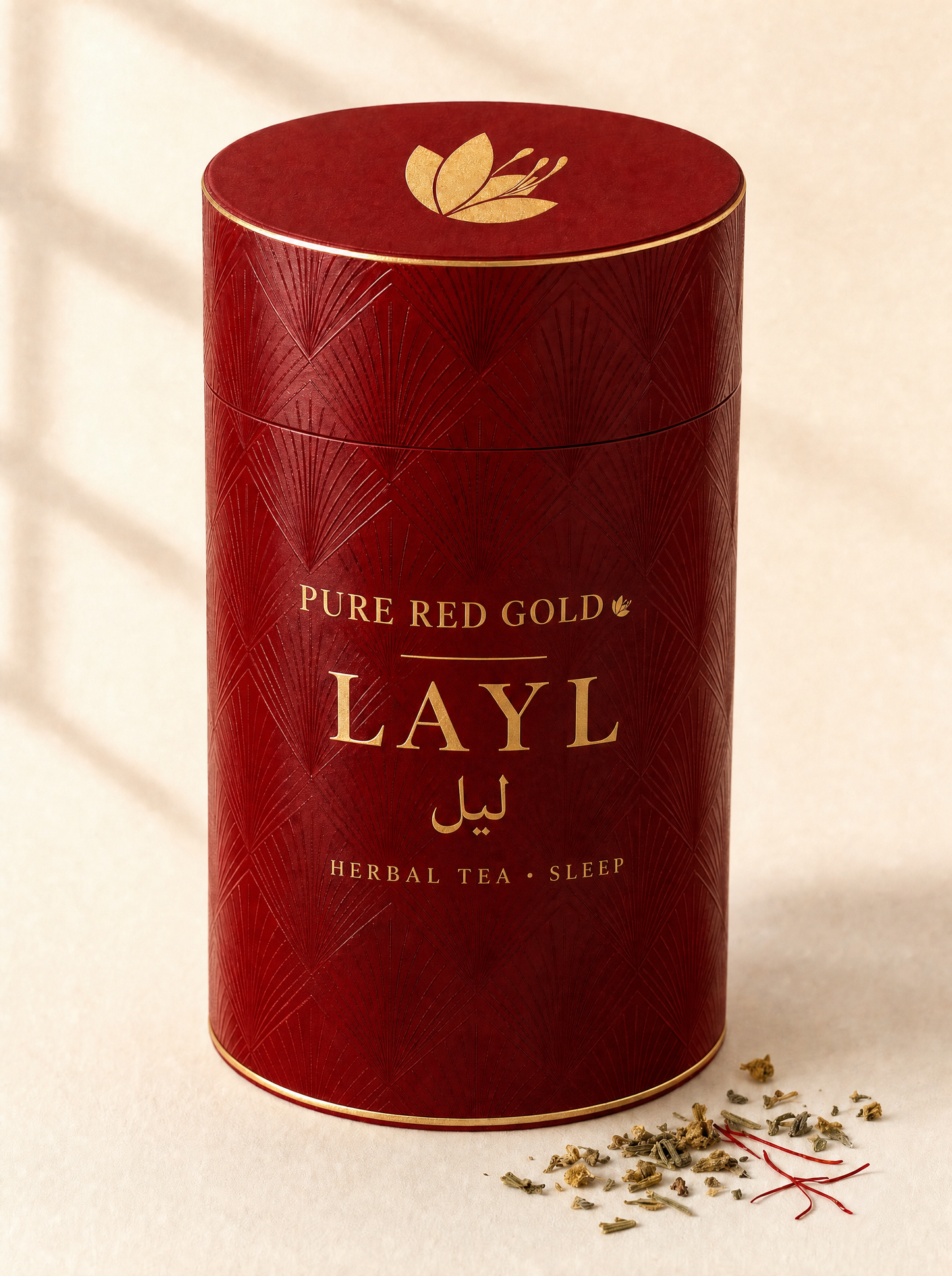 Layl herbal tea — a crimson cylinder tube with a tone-on-tone pattern, gold foil rims, the saffron crocus on the lid, and PURE RED GOLD above LAYL with its Arabic name in gold foil